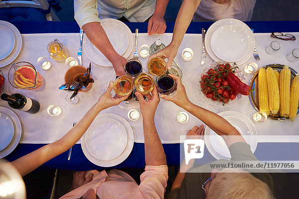 Gruppe von Personen  die am Tisch sitzen  Weingläser halten  einen Toast ausbringen  Draufsicht