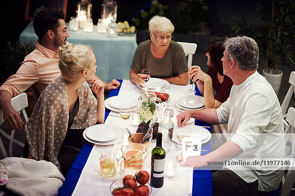 Gruppe von Personen  die am Tisch sitzen und eine Mahlzeit genießen