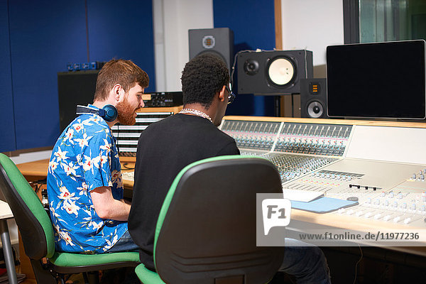 Zwei junge männliche College-Studenten am Tonmischpult im Tonstudio