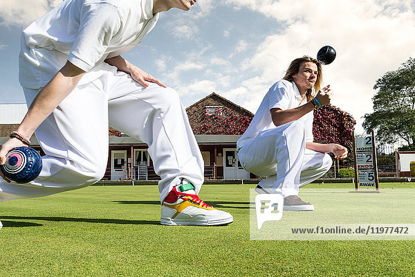 Cropped shot of two young men lawn bowling on bowling green