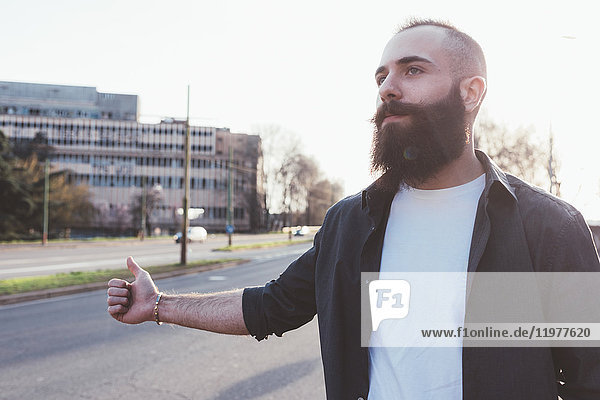 Bearded man hitchhiking