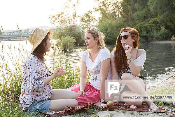 Drei Freundinnen entspannen sich am See