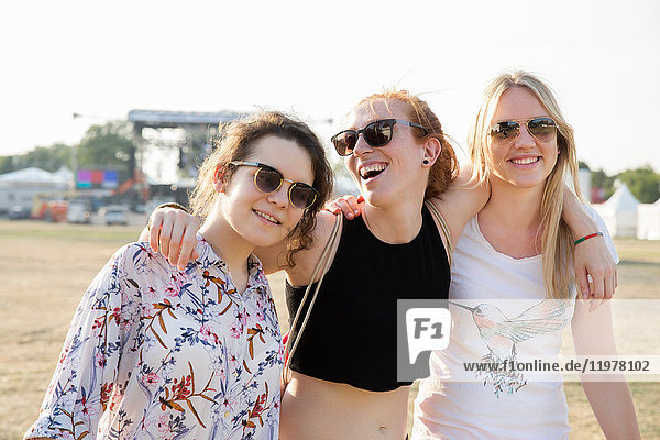Portrait of three female friends at festival  smiling