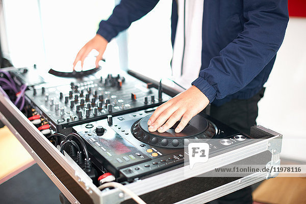 Junger männlicher College-Student dreht DJ-Plattenspieler im Aufnahmestudio