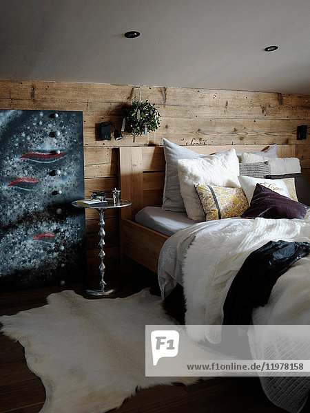Schlafzimmer innen  holzverkleidete Wand hinter dem Bett