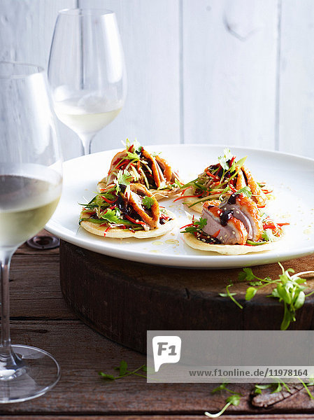 Mini-Peking-Enten-Pizzas auf weissem Teller