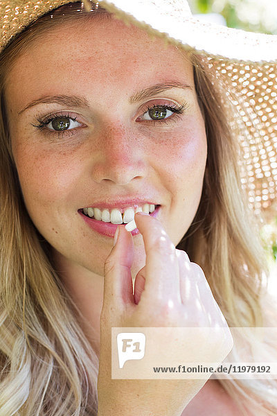MODEL RELEASED. Young woman taking tablet  smiling.