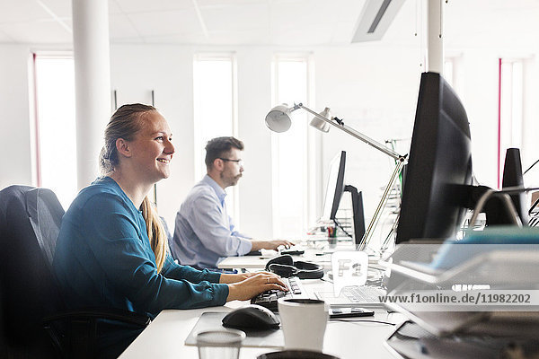 Colleagues working at computers in office