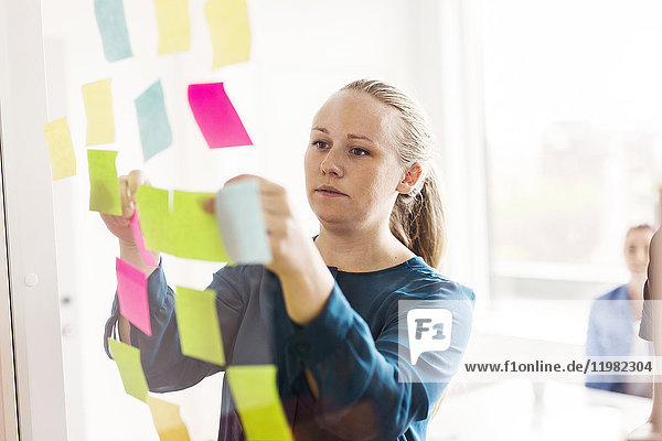Young woman looking at adhesive notes