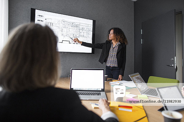 Architects discussing blueprint in office