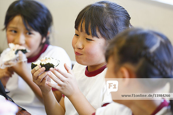 Japanische Grundschulkinder beim Essen im Klassenzimmer