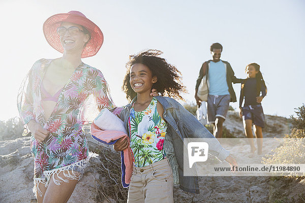 Lächelnder Familienspaziergang auf dem sonnigen Strandberg im Sommer
