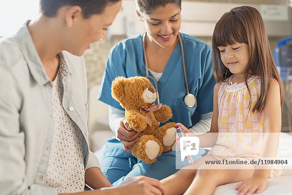 Weibliche Krankenschwester mit Teddybär beobachtet Mädchen Patient mit Insulin-Pen im Krankenhaus Zimmer