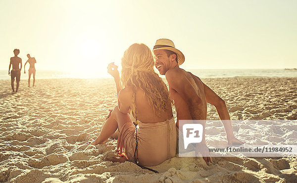 Young couple relaxing on sunny summer beach