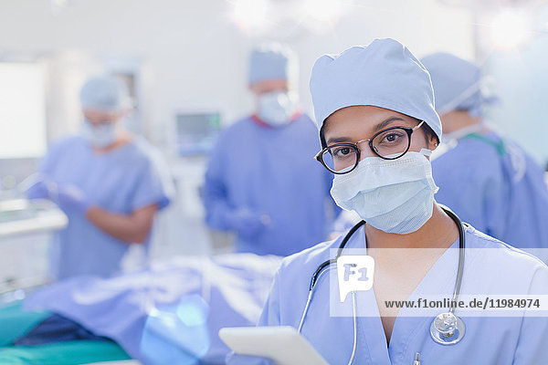 Porträt einer selbstbewussten Chirurgin mit chirurgischer Maske im Operationssaal