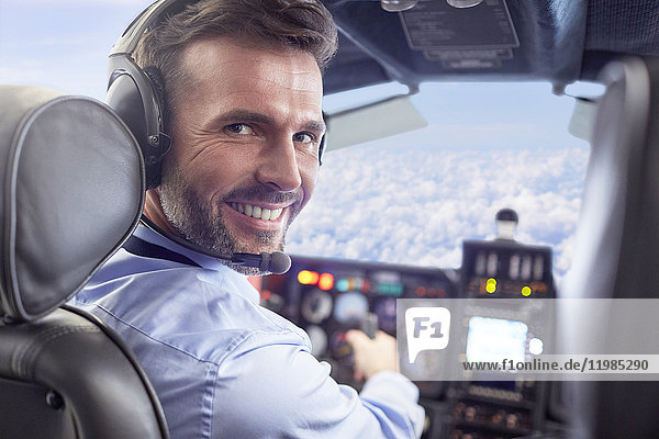 Portrait lächelndes  selbstbewusstes männliches Flugzeug im Cockpit