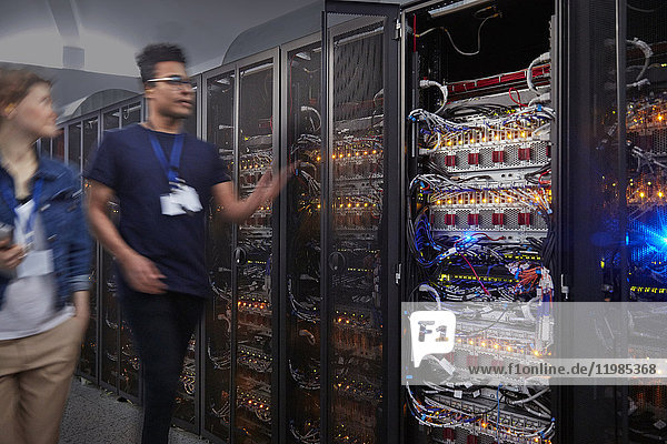 IT technicians walking along panels in server room