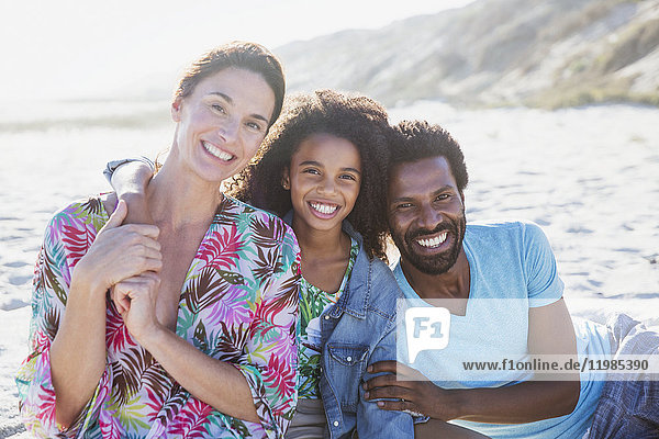 Portrait smiling  affectionate multi-ethnic family on sunny summer beach