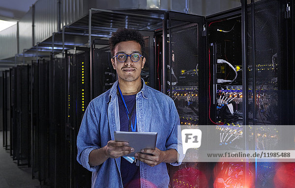 Portrait confident male IT technician with digital tablet in server room