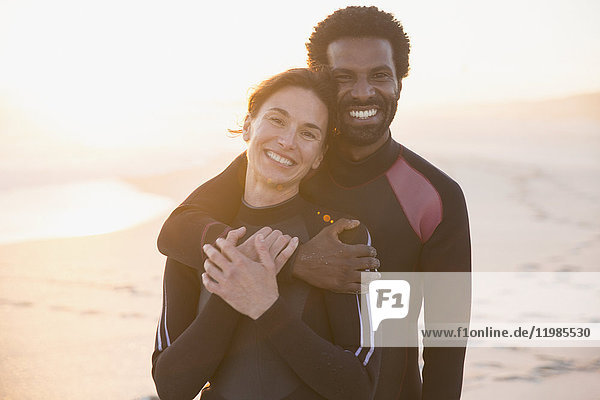 Portrait smiling  affectionate couple hugging on sunset summer beach