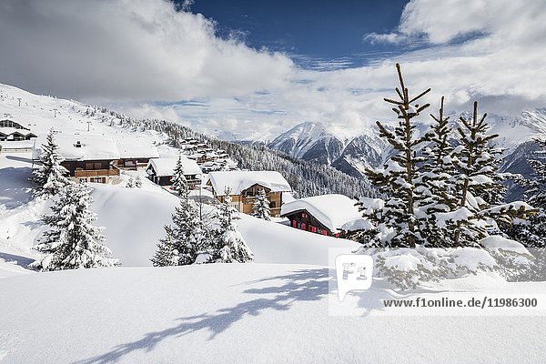 The winter sun shines on the snowy mountain huts and woods Bettmeralp district of Raron canton of Valais Switzerland Europe.