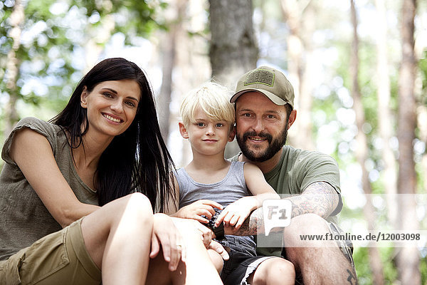 Portrait of happy family with son in forest