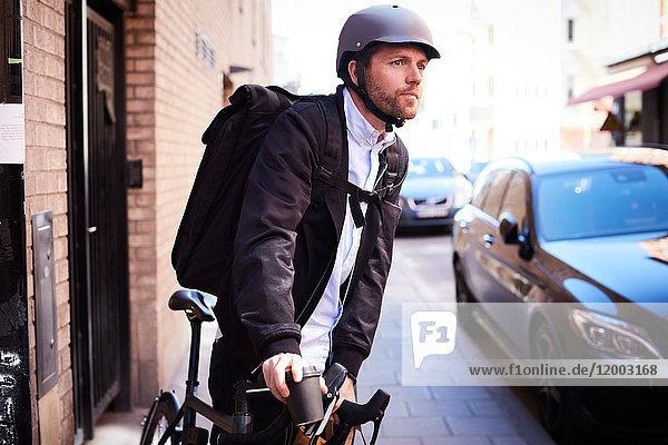 Geschäftsmann mit dem Fahrrad auf der Straße in der Stadt