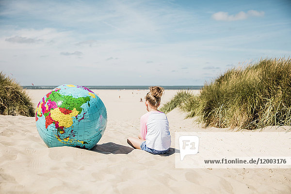 Mädchen mit Globus am Strand