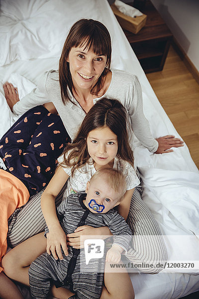 Happy mother in bed with her three children