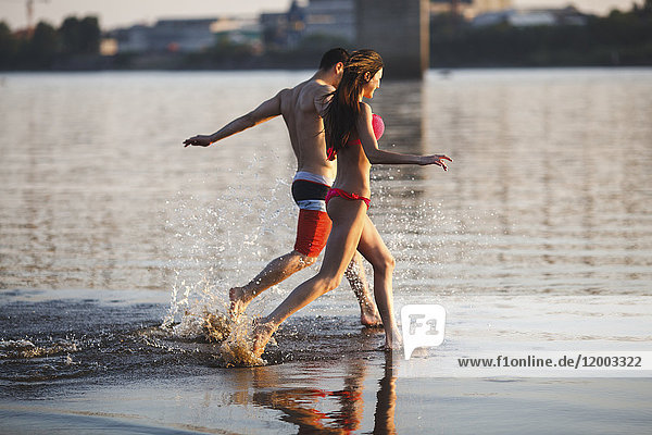 Happy couple running in water