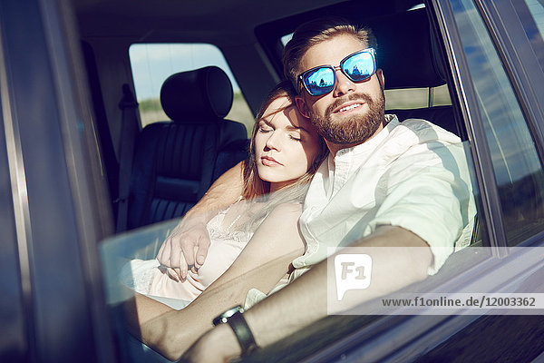 Zärtliches junges Paar entspannt im Auto
