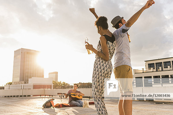Young couple dancing on a rooftop party