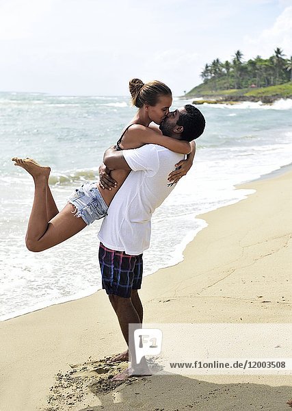 Happy couple kissing on the beach