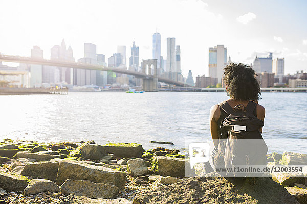 USA  New York City  Brooklyn  Frau am Wasser sitzend