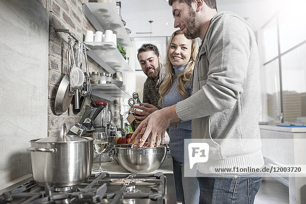 Friends preparing a meal in kitchen