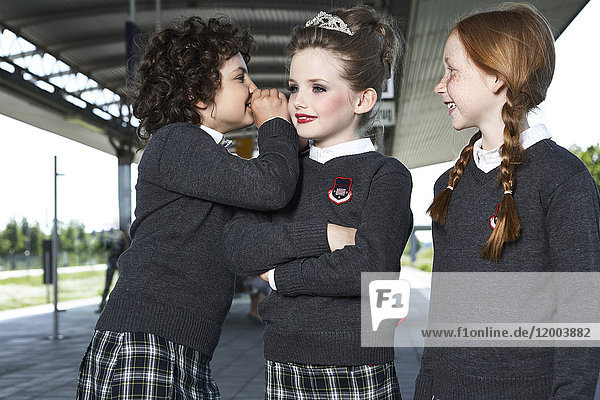 Drei Mädchen auf dem Bahnsteig in Schuluniform