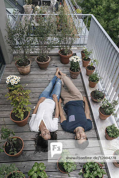 Entspanntes Paar auf dem Balkon liegend