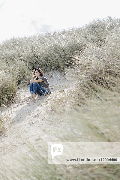 Woman sitting in beach dune