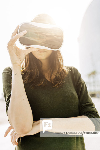 Junge Frau mit VR-Brille im Freien