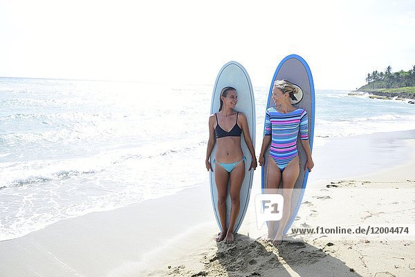 Zwei Frauen am Strand mit Surfbrettern