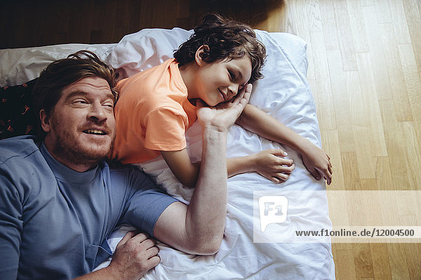 Father and son relaxing on bed