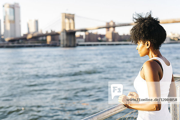 USA  New York City  Brooklyn  Frau am Wasser stehend