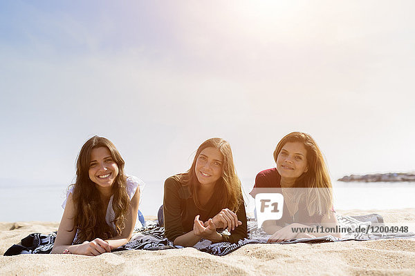 Porträt von drei Freundinnen  die sich am Strand entspannen
