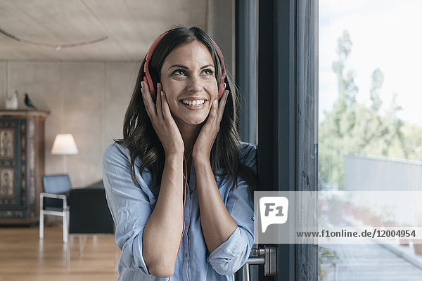 Smiling woman listening to music at home