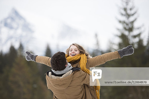 Glückliches junges Paar mit Spaß im Winterwald