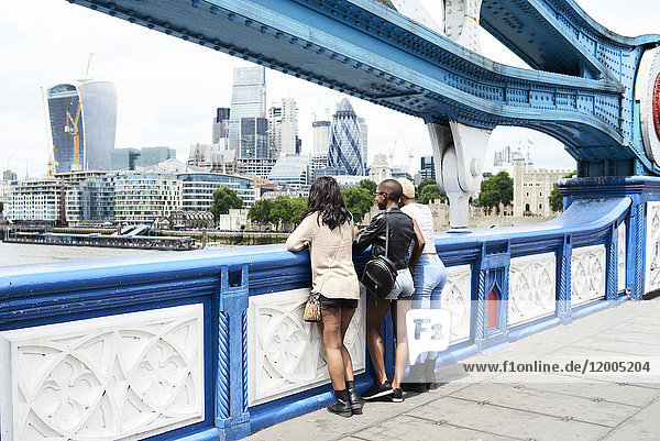 UK  London  Rückansicht von drei Freunden mit Blick auf die Skyline