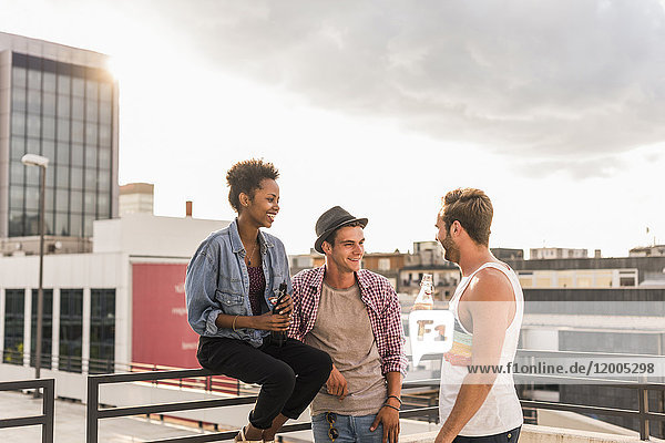 Three friends socializing on a rooftop party