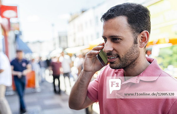 UK  London  Portobello Road  Porträt eines lächelnden Mannes am Telefon