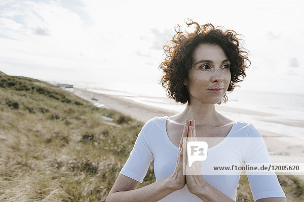Woman with folded hands in beach dune
