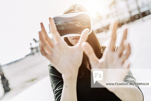 Junge Frau mit VR-Brille im Freien
